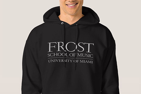 A man wearing a black sweatshirt showcasing the words FROST School of Music