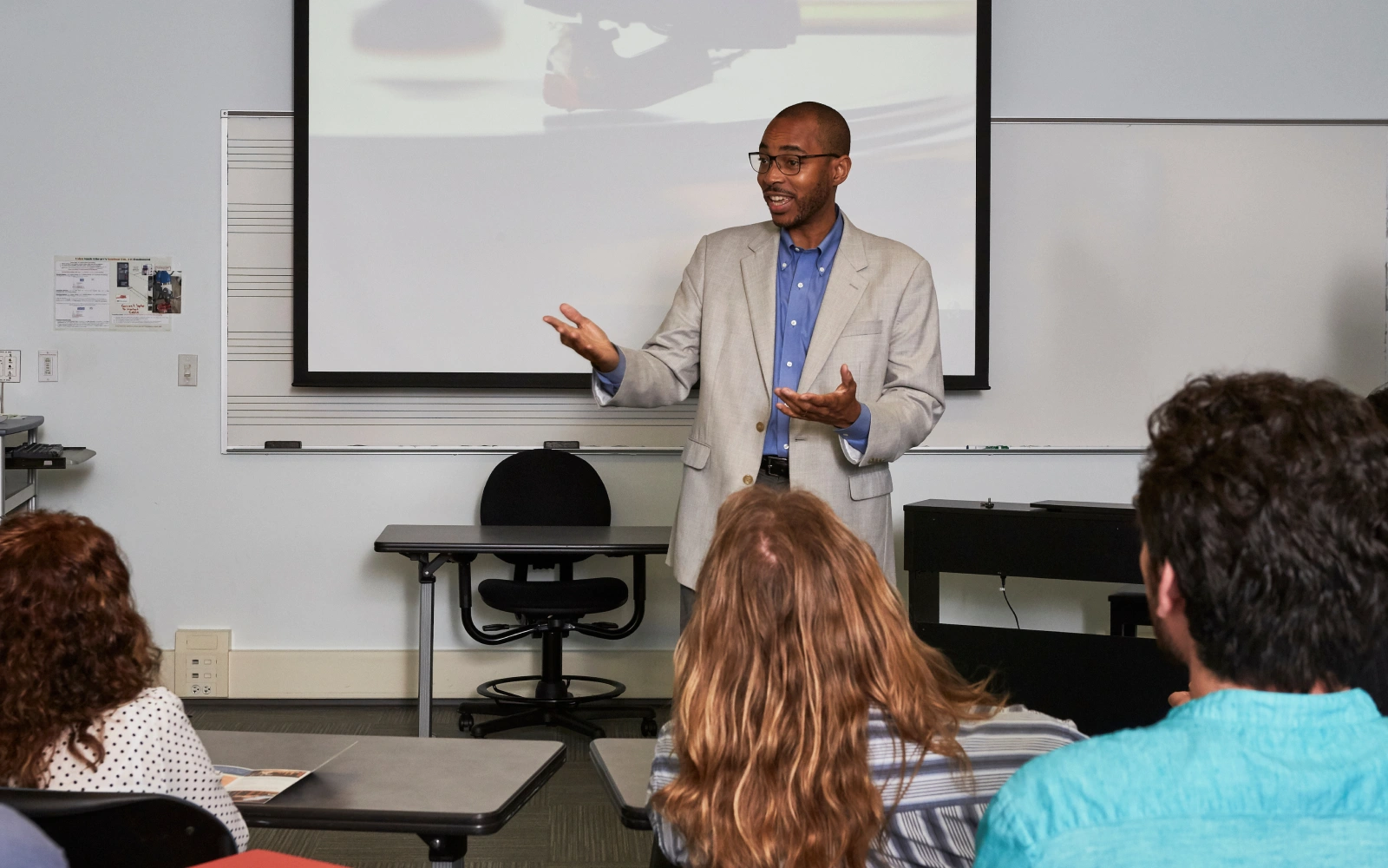 A teacher standing in front of a class teaching