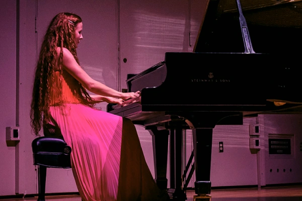 A student playing a piano